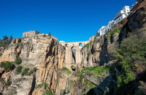 Bridge Puente Nuevo with waterfall at steep cliffs