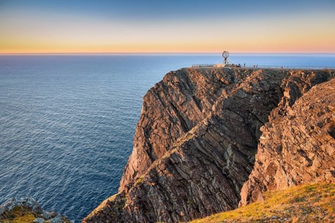 North Cape cliff with steel globe in the light of the midnight sun