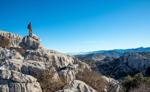 Young man standing on rocks and looking into the distance