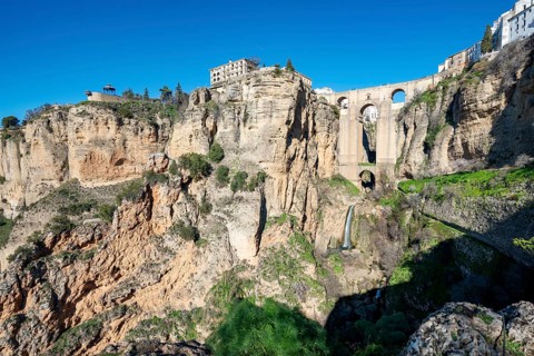 Bridge Puente Nuevo with waterfall at steep cliffs