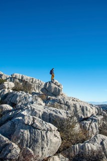 Young man standing on rocks and looking into the distance