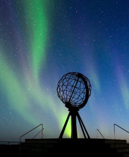 Steel globe at North Cape with northern lights