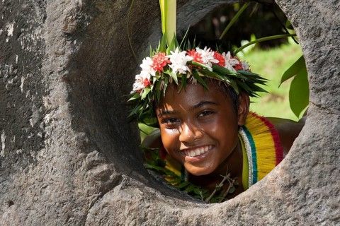 Native boy from Yap looks through stone money hole