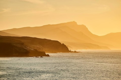 Beach Playa de la Pared with rocky coast at sunset