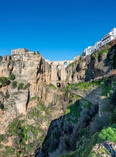 Bridge Puente Nuevo with waterfall at steep cliffs