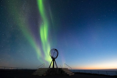 Steel globe at North Cape with northern lights