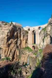 Bridge Puente Nuevo with waterfall at steep cliffs