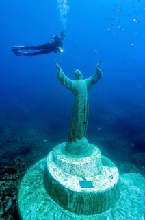 Diver at Christ statue under water