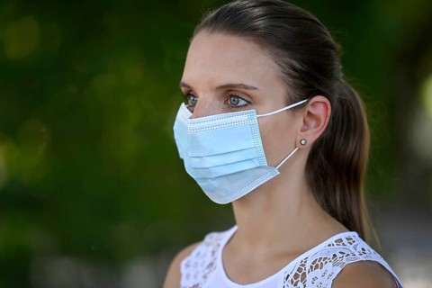 Woman wears mouth mask correctly over nose and mouth