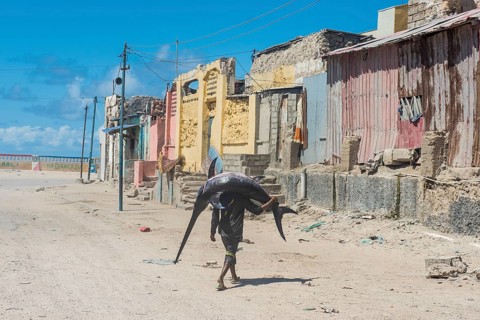 Man carrying a giant swordfish to the fishmarket of Mogadishu