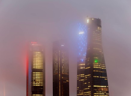Cuatro Torres Business Area Office building illuminated in evening fog