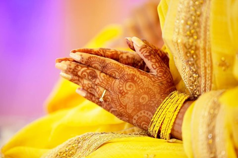 Hindu Bride crossing hands painted with henna for prayer on wedding eve