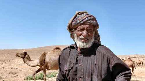 Camel breeder with camels in the mountains north of Salalah