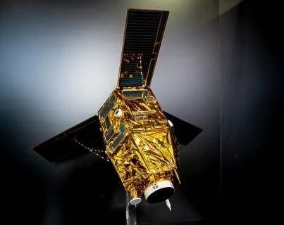 Model of a satellite with solar panel and golden heat protection foil