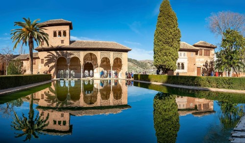Historic building El Partal with pool and palm trees