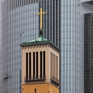 Old bell tower of the Matthaeuskirche in front of the modern aluminium facade of the Pollux office tower
