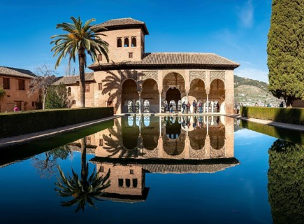 Historic building El Partal with pool and palm trees