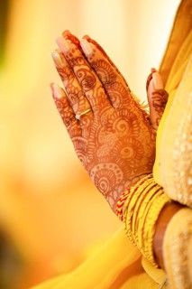 Hindu Bride crossing hands painted with henna for prayer on wedding eve