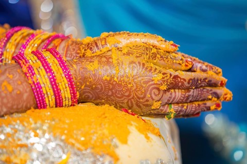 Hindu Bride crossing hands painted with henna for prayer on wedding eve