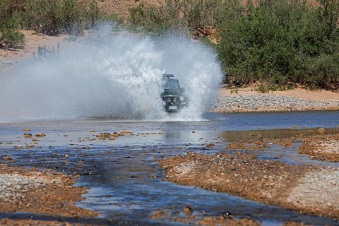 Off-road vehicle crosses a river in the Middle Atlas
