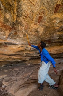 Guide pointing at cave paintings in Laas Geel caves