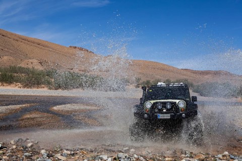 Off-road vehicle crosses a river in the Middle Atlas