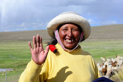 Indigenous woman waves into the camera