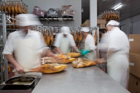 Employees select pieces from Jamon Serrano for packaging