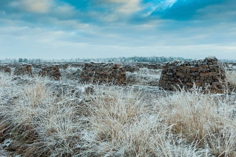 Piled up peat sods in the bog in winter at hoarfrost