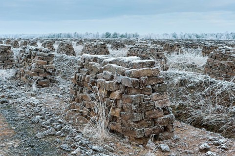Piled up peat sods in the bog in winter at hoarfrost