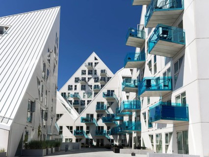 White residential complex with turquoise balconies against a blue sky