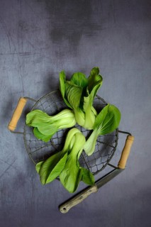 Pak Choi or Chinese mustard cabbage in wire basket with knife