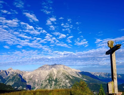 Summit cross of the Rotspielscheibe with view of Watzmann with the east face