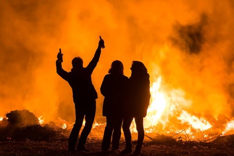 Silhouettes of three people at an Easter fire