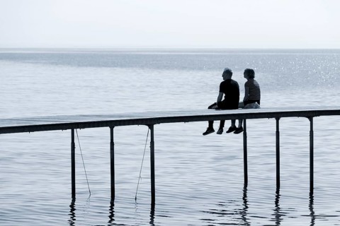 Couple sitting on bathing jetty