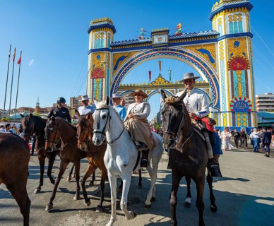 Riders on decorated horses in traditional dress in front of the entrance gate