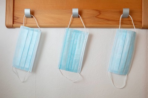Corona protection masks hanging on coat hooks
