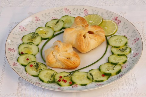 Puff pastry pocket enriched with cucumbers and slices of lime on plates