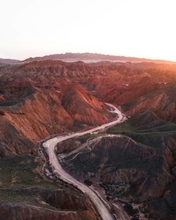 Red sandstone mountains of different minerals with a road in the foreground