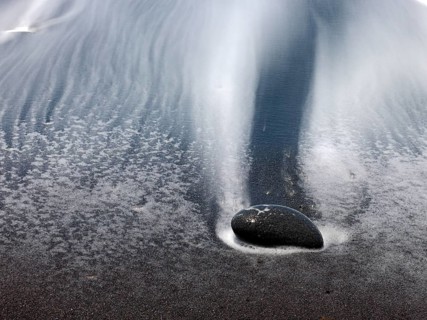 Black stones and sand with run-off water