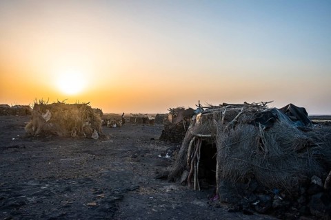 Village with huts of the Afar nomads at sunset