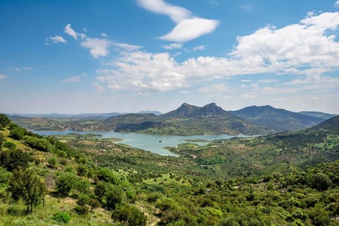 View over green hilly landscape with Zahara-El Gastor Reservoir