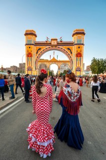 Spanish women with flamenco dresses in front of the illuminated Portada