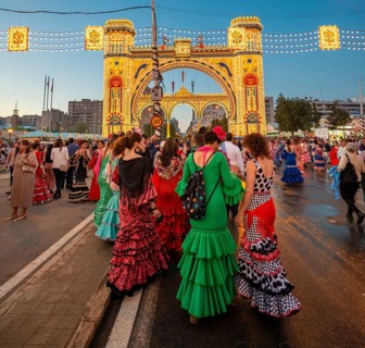 Spanish women with flamenco dresses in front of the illuminated Portada