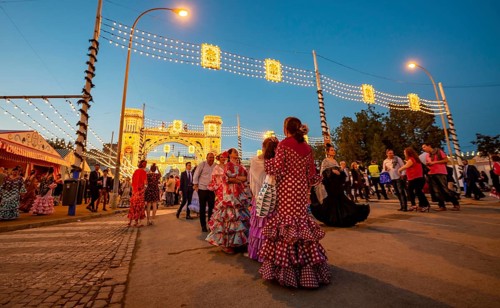 Spanish women with flamenco dresses in front of the illuminated Portada