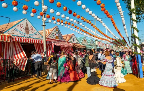 Celebrating Spaniards in traditional dress in front of marquees