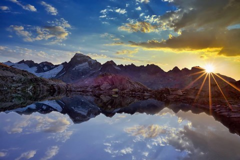 Graetlisee with reflection of the mountains and clouds at sunrise