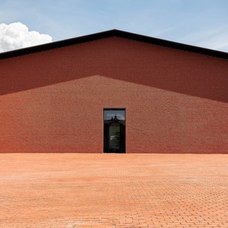 Windowless red brick building in the shape of a warehouse