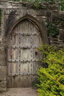 Old wooden door in the gardens of Victorian manor house Lanhydrock House