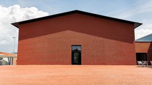 Windowless red brick building in the shape of a warehouse